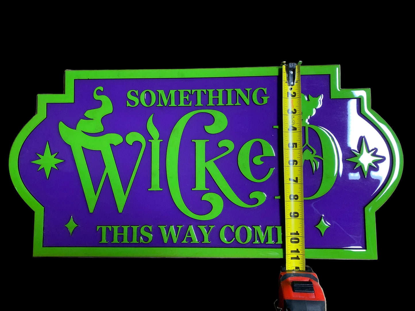 Decorative handmade sign with 'Something Wicked This Way Comes' text