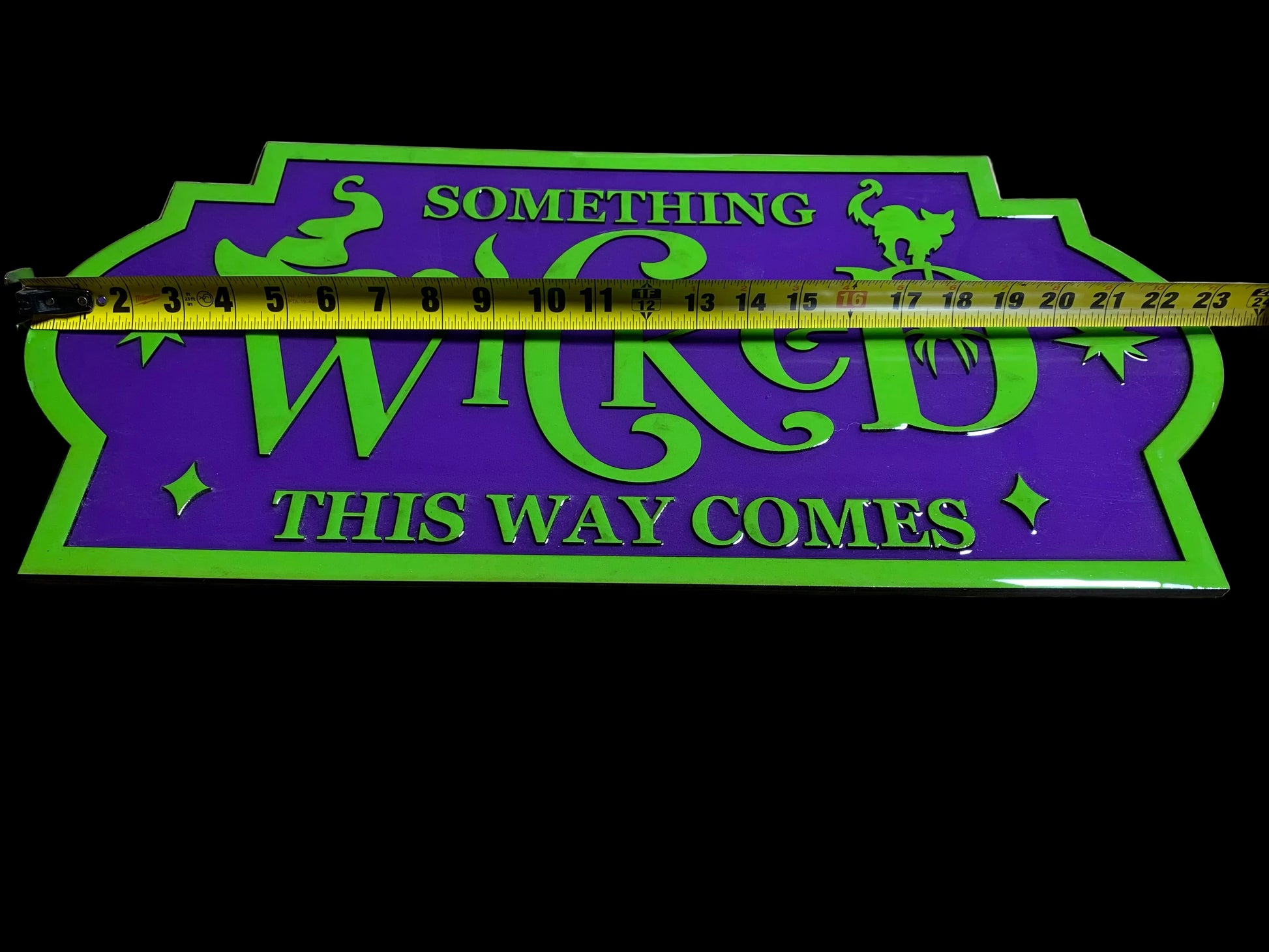 Decorative handmade sign with 'Something Wicked This Way Comes' text